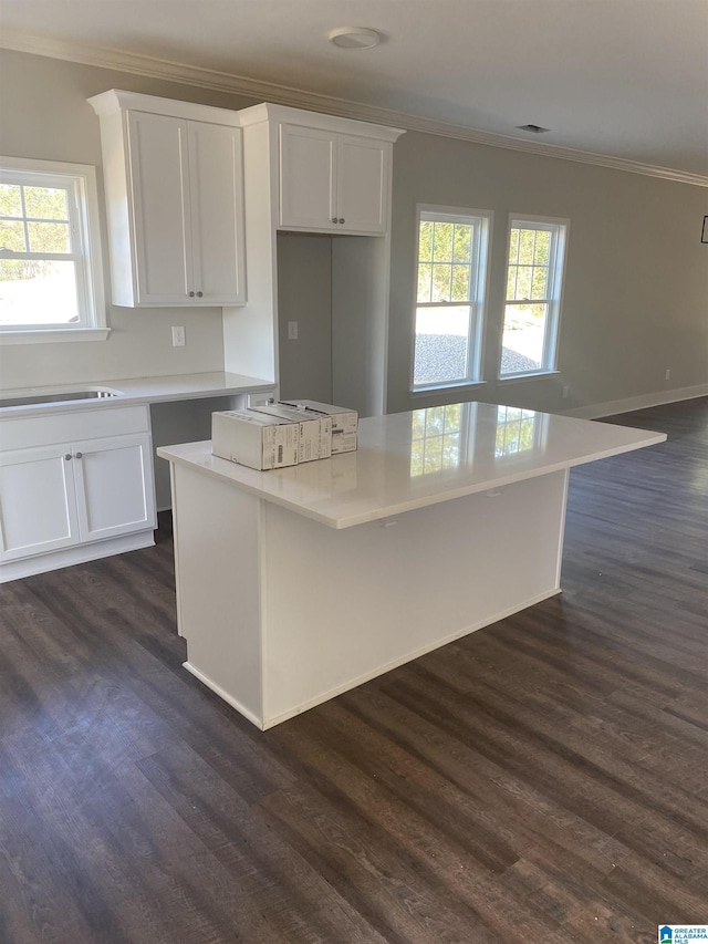 kitchen featuring white cabinets, dark hardwood / wood-style flooring, a center island, and plenty of natural light