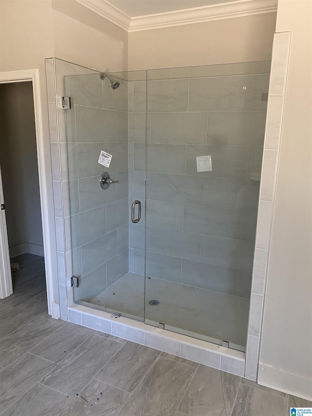 bathroom with crown molding and an enclosed shower