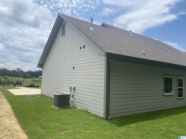 view of side of home featuring a lawn and central air condition unit