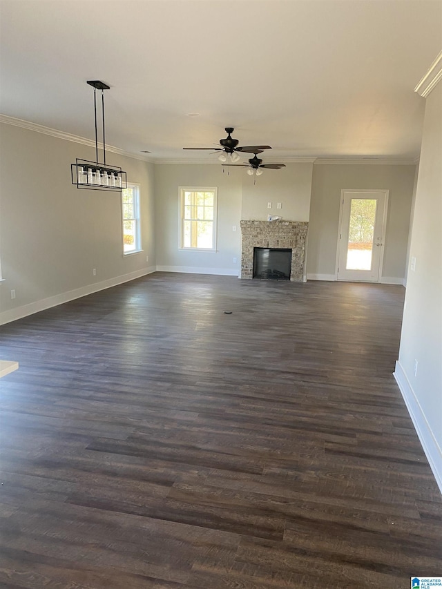 unfurnished living room featuring plenty of natural light, crown molding, and dark wood-type flooring