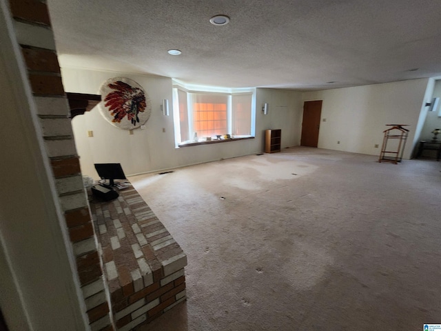 unfurnished living room featuring carpet floors and a textured ceiling