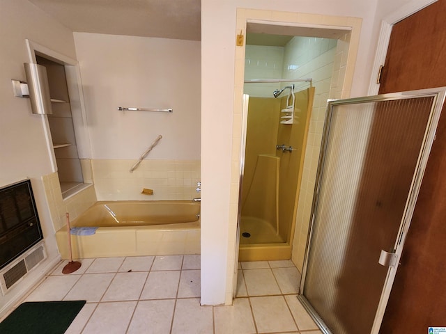 bathroom featuring tile patterned flooring, independent shower and bath, and heating unit