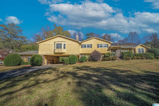 split level home with a front lawn and a carport