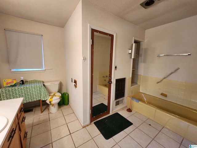 bathroom with tile patterned floors, a bathtub, toilet, and vanity