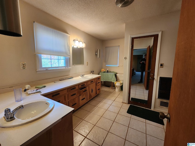 bathroom featuring tile patterned flooring, vanity, a textured ceiling, and toilet