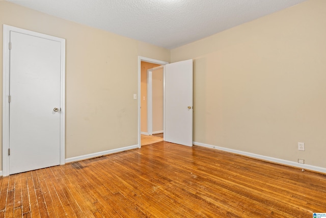 unfurnished room featuring a textured ceiling and hardwood / wood-style flooring