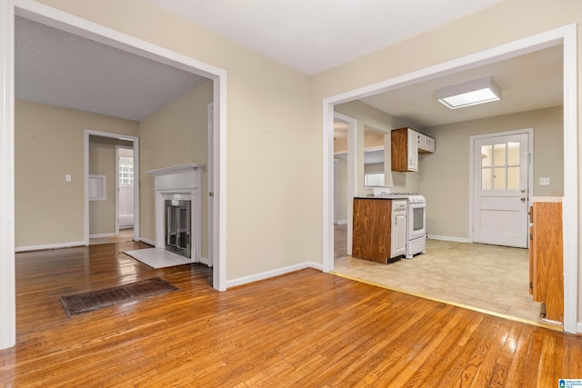 kitchen with white range oven and light hardwood / wood-style flooring