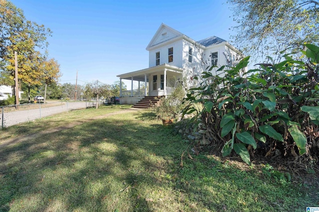 view of side of property featuring a lawn and a porch