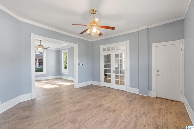 empty room featuring french doors, light hardwood / wood-style floors, ceiling fan, and crown molding