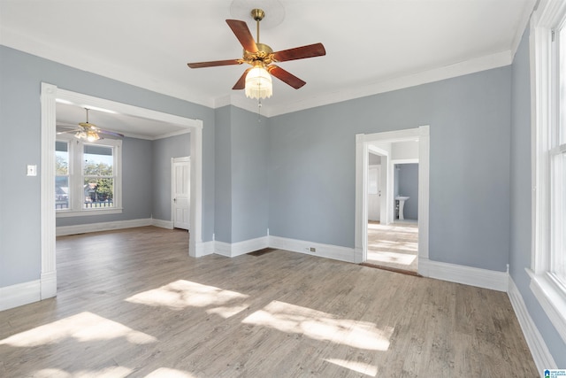 empty room featuring ceiling fan, light hardwood / wood-style floors, and crown molding