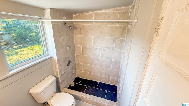 bathroom with tiled shower and toilet