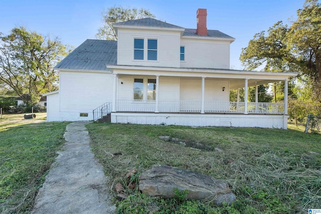 rear view of property featuring a yard and covered porch