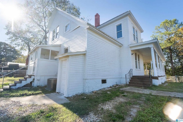 view of side of home featuring a porch and central air condition unit