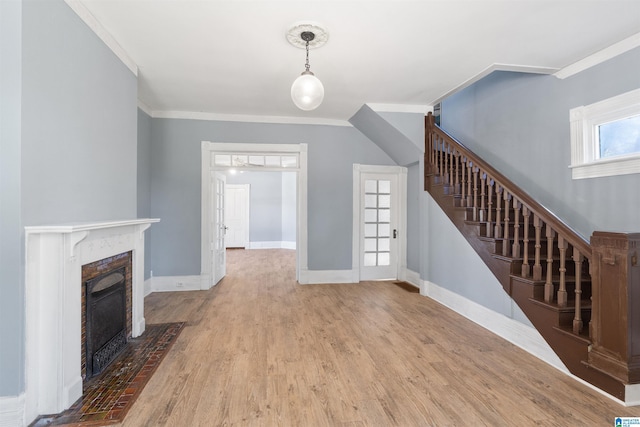 unfurnished living room featuring a wealth of natural light, hardwood / wood-style floors, and crown molding