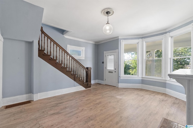 foyer entrance with light hardwood / wood-style flooring and ornamental molding