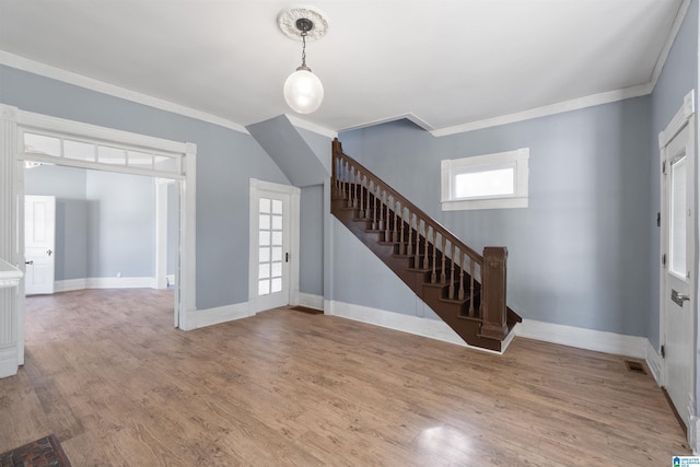 foyer featuring hardwood / wood-style floors, ornamental molding, and a healthy amount of sunlight