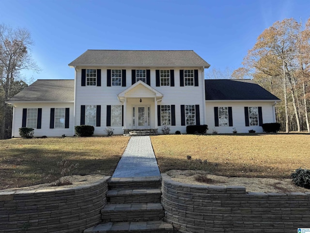 colonial inspired home with a front lawn