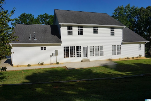 back of property with a lawn and a patio