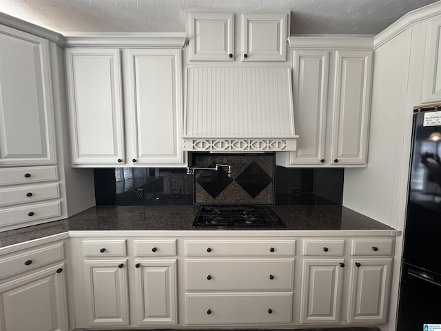 kitchen with black appliances, white cabinetry, and extractor fan