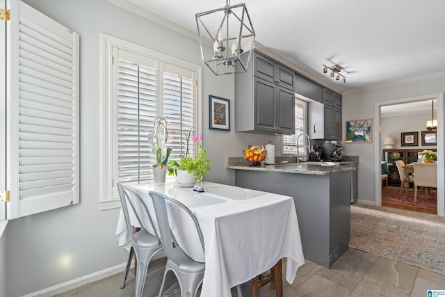 dining room with crown molding, sink, and a notable chandelier