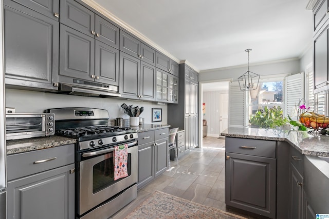 kitchen featuring gray cabinets, stainless steel range with gas cooktop, ornamental molding, and dark stone countertops