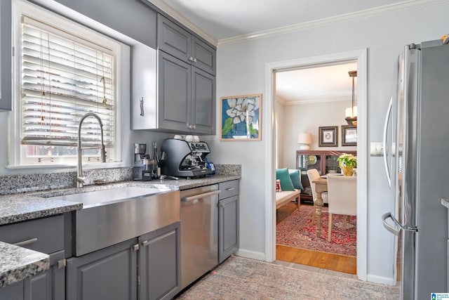 kitchen with gray cabinets, light stone countertops, stainless steel appliances, and light hardwood / wood-style floors