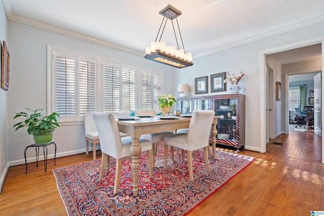 dining area with a wealth of natural light, light hardwood / wood-style flooring, and ornamental molding