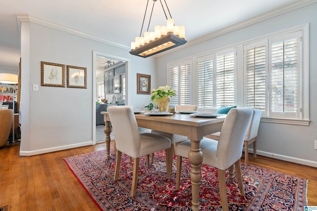 dining room with a wealth of natural light, crown molding, and hardwood / wood-style flooring