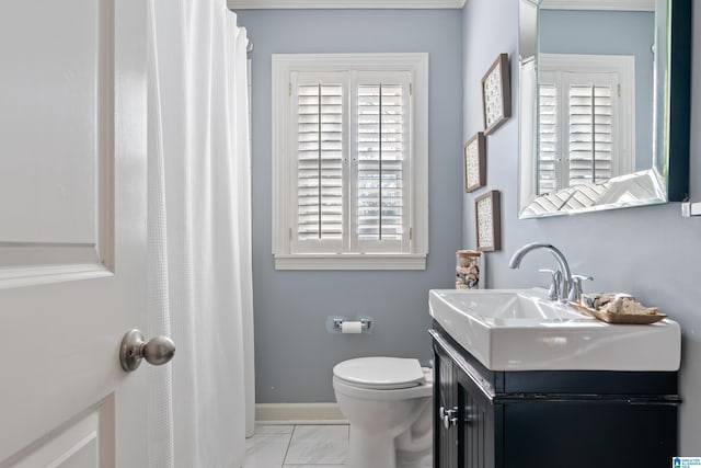 bathroom featuring plenty of natural light, toilet, and vanity