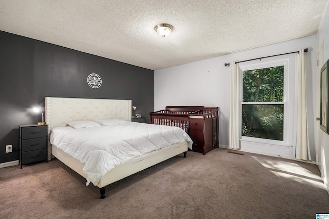 bedroom with carpet floors and a textured ceiling