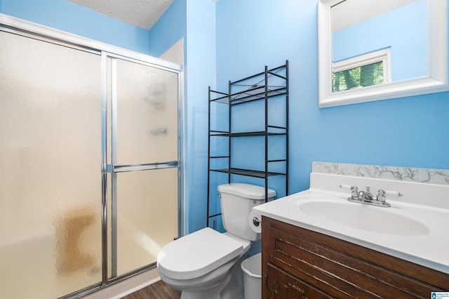 bathroom with wood-type flooring, an enclosed shower, toilet, a textured ceiling, and vanity