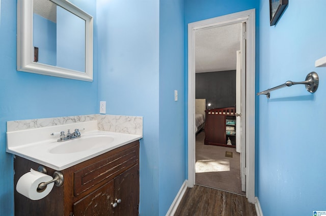 bathroom featuring vanity, hardwood / wood-style floors, and a textured ceiling