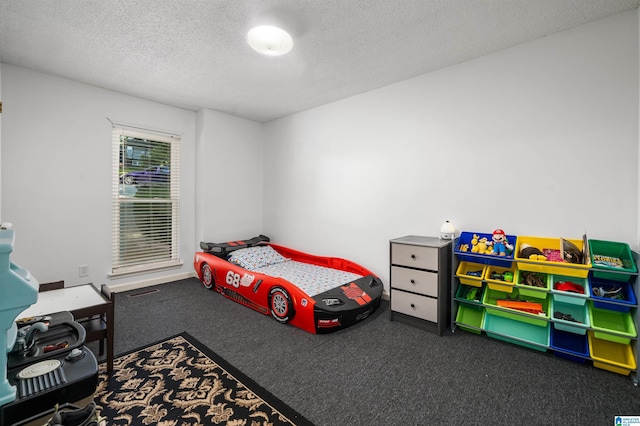 bedroom featuring dark carpet and a textured ceiling