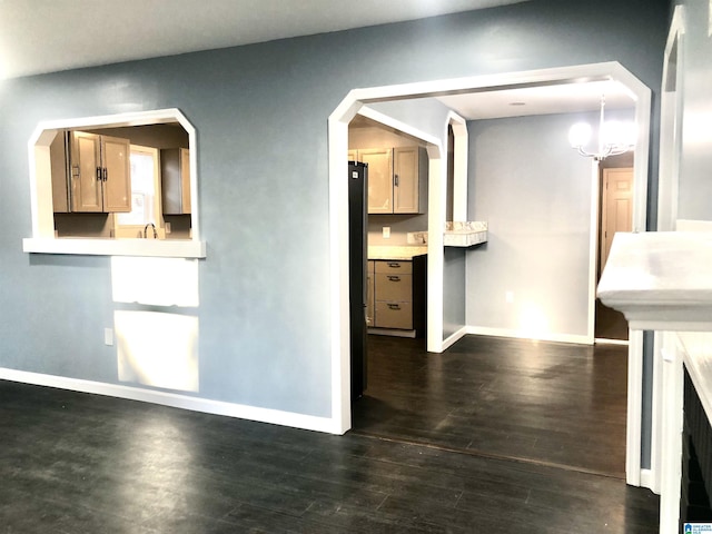 unfurnished living room featuring dark hardwood / wood-style floors and a notable chandelier