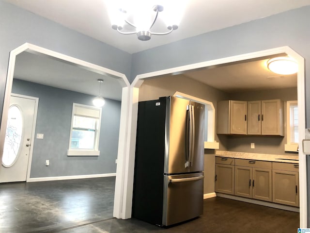 kitchen featuring stainless steel fridge, light brown cabinetry, a notable chandelier, dark hardwood / wood-style floors, and hanging light fixtures