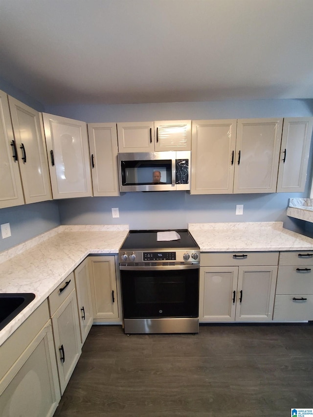 1245 16th St SW, Birmingham, AL 35211 - kitchen featuring appliances with stainless steel finishes, dark wood-style floors, and light stone countertops