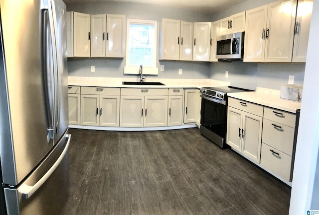 kitchen with white cabinets, dark hardwood / wood-style flooring, stainless steel appliances, and sink