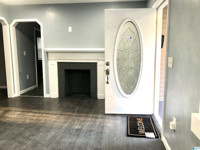 entrance foyer featuring a fireplace and dark wood-type flooring