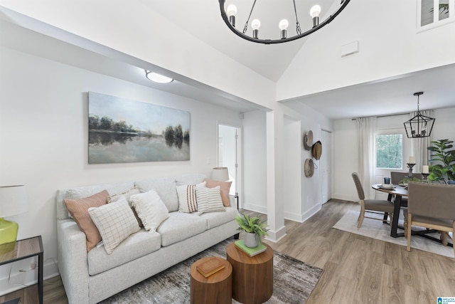 living room featuring a chandelier, hardwood / wood-style flooring, and lofted ceiling