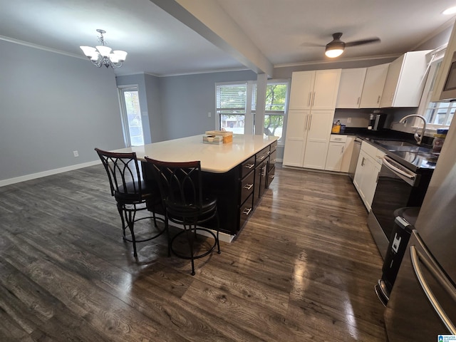 kitchen featuring sink, a kitchen island, dark hardwood / wood-style flooring, decorative light fixtures, and white cabinets