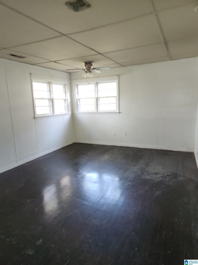 empty room featuring a paneled ceiling, dark hardwood / wood-style floors, and ceiling fan