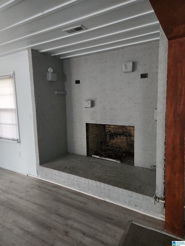 interior details with wood-type flooring and a brick fireplace