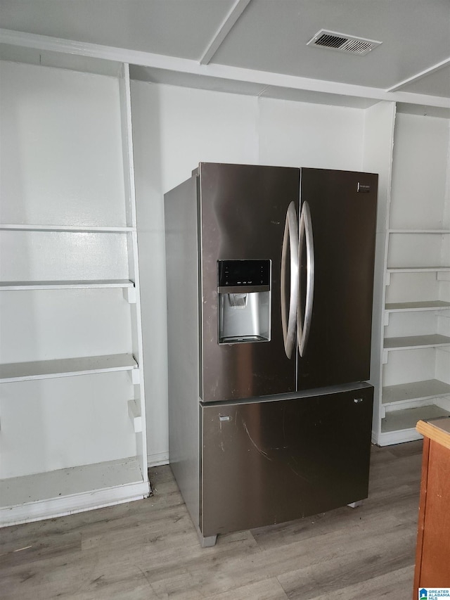 interior details with stainless steel fridge and hardwood / wood-style flooring