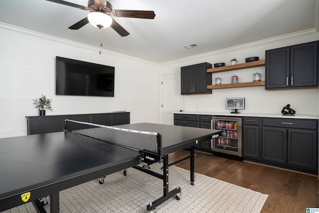 playroom featuring wine cooler, ceiling fan, dark wood-type flooring, and crown molding