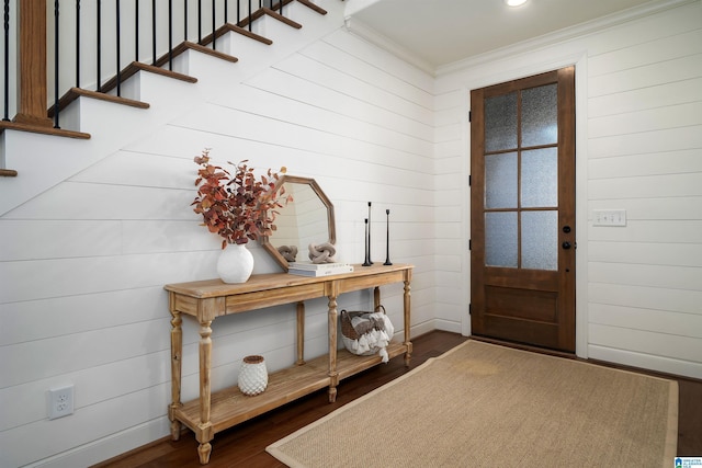 entryway featuring hardwood / wood-style floors, wood walls, and crown molding