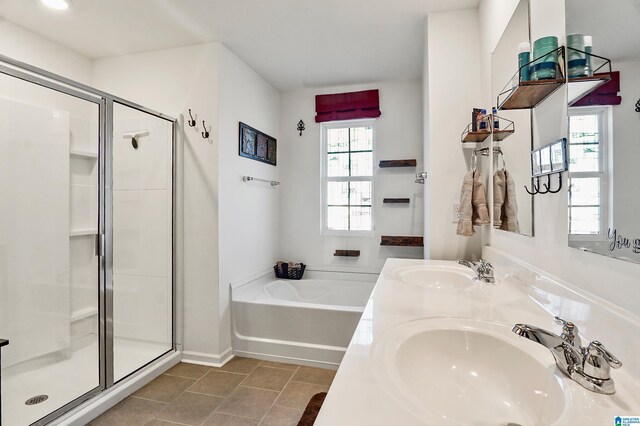 bathroom featuring plus walk in shower, vanity, and tile patterned floors