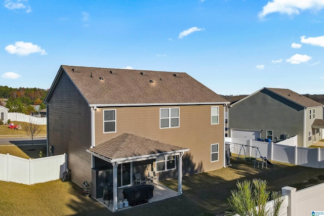 rear view of property featuring a playground, a patio area, and a lawn