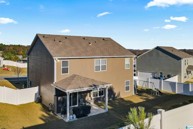 back of house featuring a lawn, a playground, and a patio