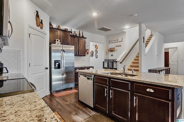 kitchen featuring sink, decorative backsplash, light stone countertops, dark hardwood / wood-style flooring, and stainless steel appliances