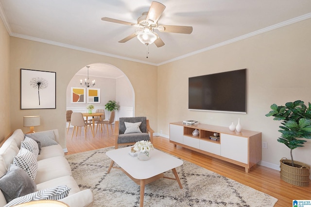 living room with ceiling fan with notable chandelier, light hardwood / wood-style floors, and ornamental molding